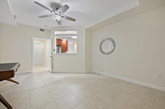 tiled spare room with ceiling fan