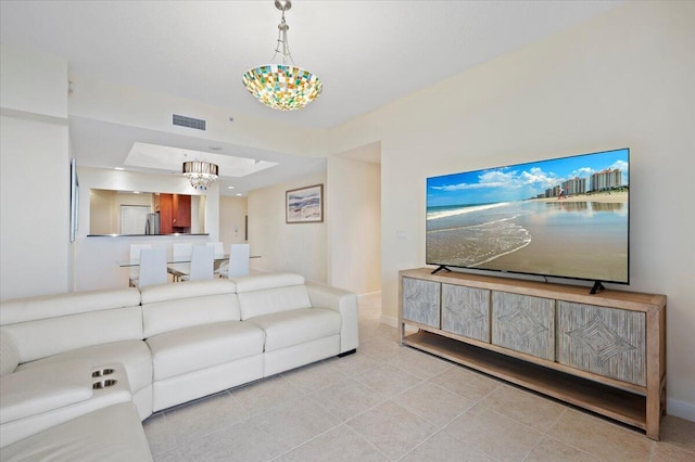 living room with tile patterned floors and an inviting chandelier