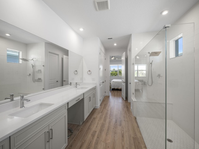 bathroom featuring tiled shower, vanity, and hardwood / wood-style flooring