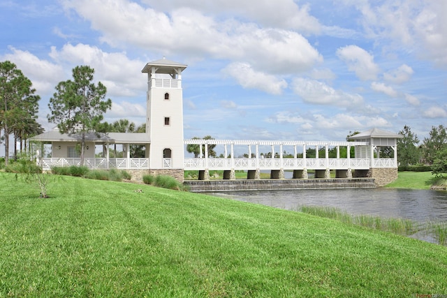 view of property's community featuring a lawn and a water view