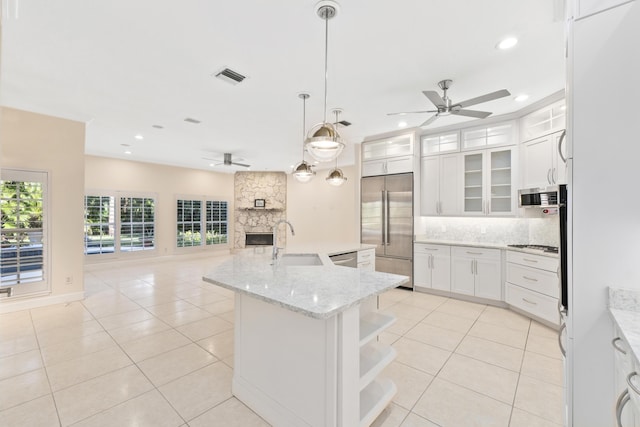 kitchen featuring appliances with stainless steel finishes, an island with sink, white cabinetry, and sink