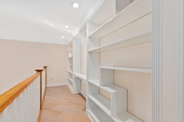 hall featuring light hardwood / wood-style flooring and crown molding