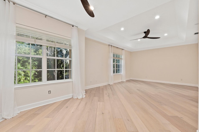 spare room featuring ceiling fan, a tray ceiling, light hardwood / wood-style flooring, and ornamental molding