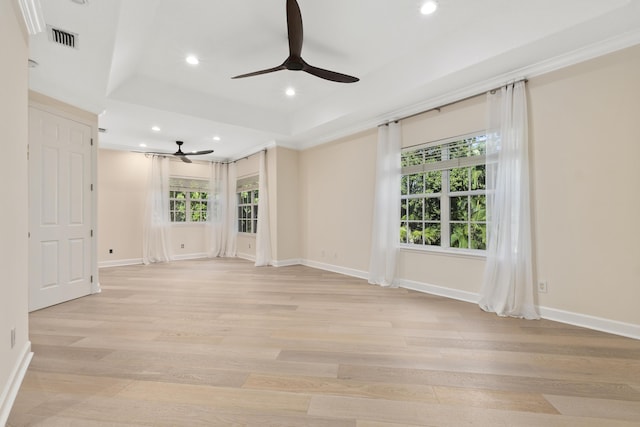 unfurnished living room featuring light hardwood / wood-style floors, a raised ceiling, and ceiling fan