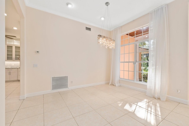 tiled spare room with a wealth of natural light, ornamental molding, and a chandelier