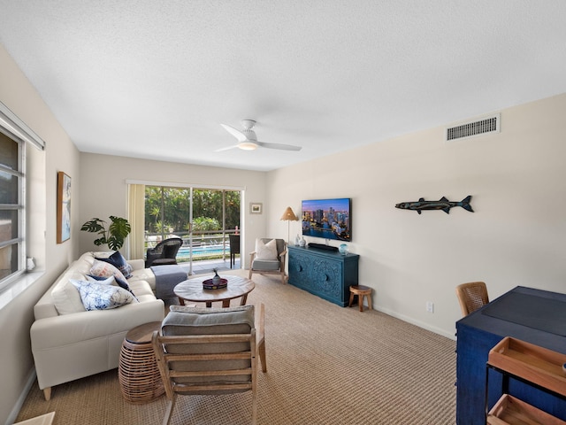 carpeted living room featuring a textured ceiling and ceiling fan