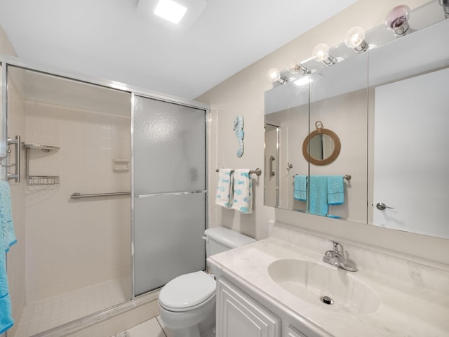 bathroom featuring tile patterned flooring, vanity, toilet, and a shower with door