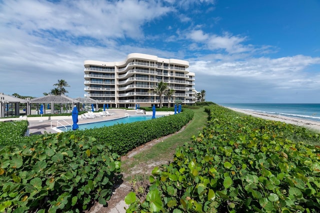 exterior space featuring a gazebo, a water view, and a beach view