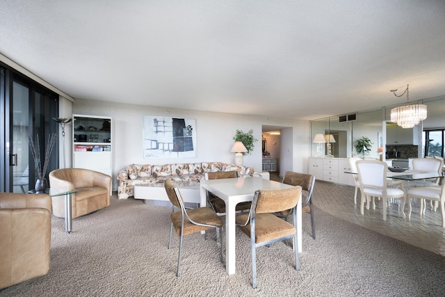 dining room featuring a notable chandelier and light colored carpet