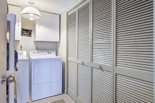 laundry area featuring washing machine and clothes dryer and a textured ceiling