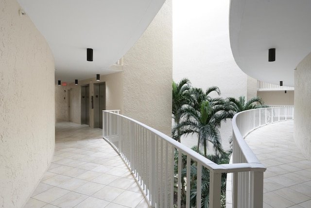 hallway featuring light tile patterned floors and elevator