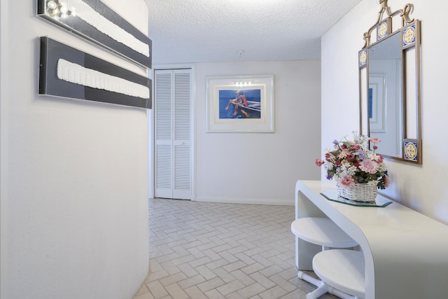 hallway with a textured ceiling