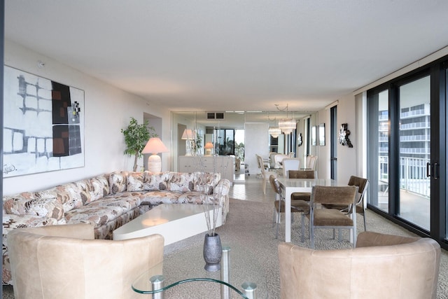 carpeted living room featuring an inviting chandelier