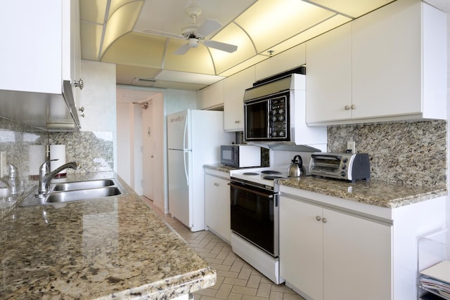 kitchen with tasteful backsplash, white cabinetry, sink, and white appliances