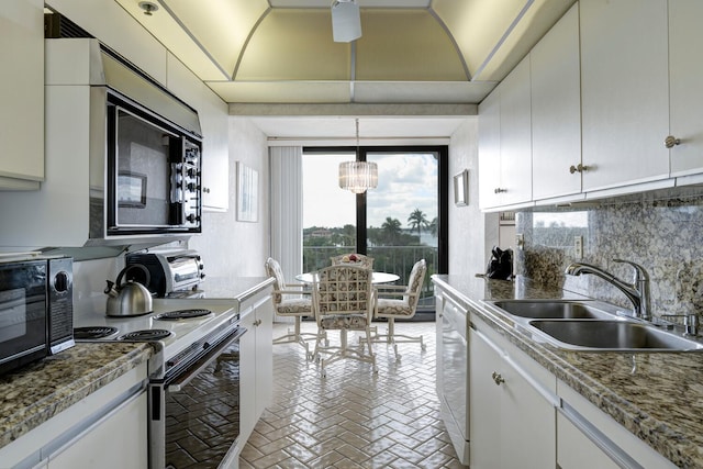 kitchen featuring sink, pendant lighting, white appliances, decorative backsplash, and white cabinets