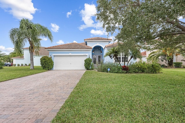 mediterranean / spanish house featuring a front yard and a garage