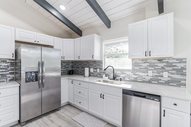 kitchen with backsplash, white cabinets, sink, and stainless steel appliances