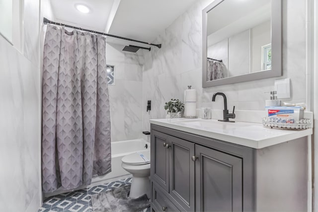 full bathroom with tile patterned floors, shower / bath combination with curtain, toilet, vanity, and tile walls