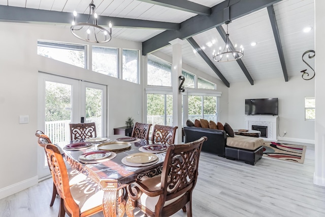 dining area featuring beam ceiling, high vaulted ceiling, an inviting chandelier, and light hardwood / wood-style flooring