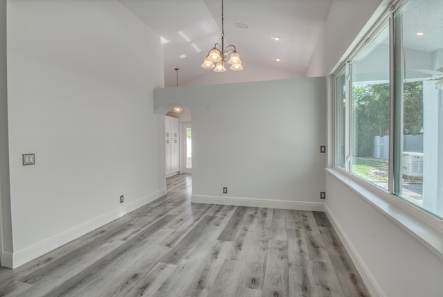 unfurnished room with light wood-type flooring, high vaulted ceiling, and an inviting chandelier