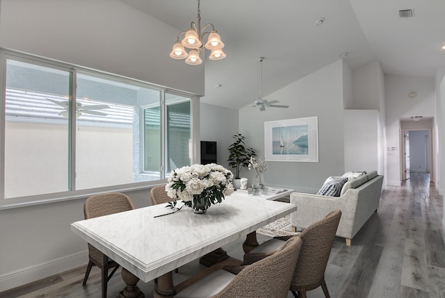 dining area with ceiling fan with notable chandelier, high vaulted ceiling, and hardwood / wood-style floors