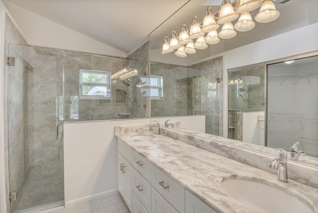 bathroom featuring a shower with door, vanity, and vaulted ceiling