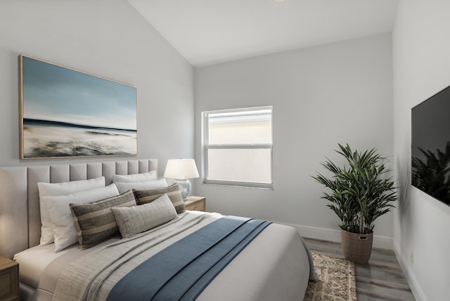 bedroom with hardwood / wood-style floors and vaulted ceiling