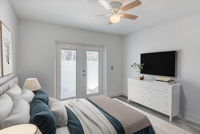 bedroom with ceiling fan, wood-type flooring, and french doors