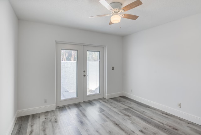 spare room with light wood-type flooring, ceiling fan, and french doors