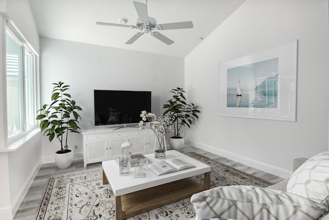 living room with vaulted ceiling, ceiling fan, light hardwood / wood-style flooring, and plenty of natural light