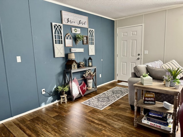 living area with crown molding, hardwood / wood-style floors, and a textured ceiling