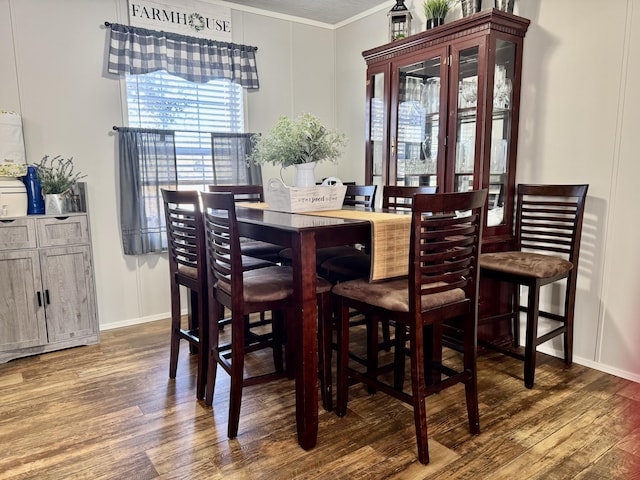 dining room with crown molding and dark wood-type flooring