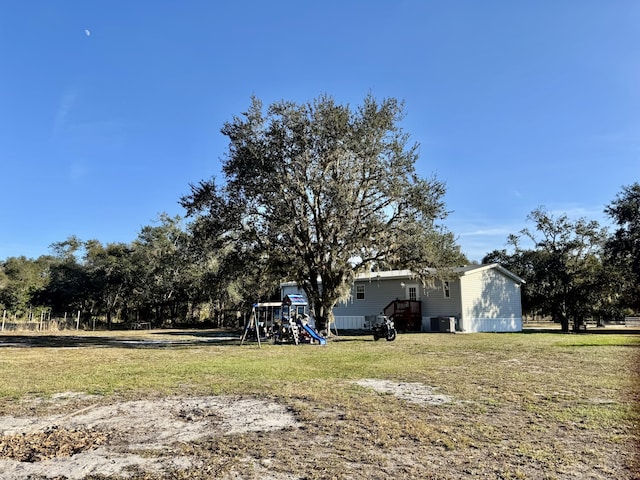 view of yard with a playground and central AC