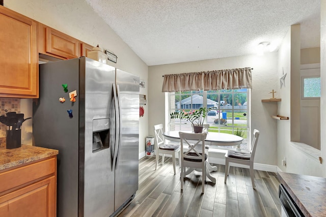 kitchen featuring stainless steel refrigerator with ice dispenser, a textured ceiling, vaulted ceiling, and dark wood-type flooring