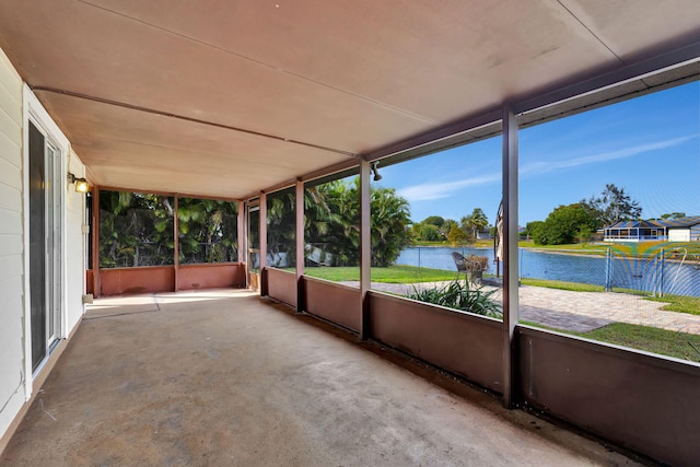 unfurnished sunroom featuring a water view