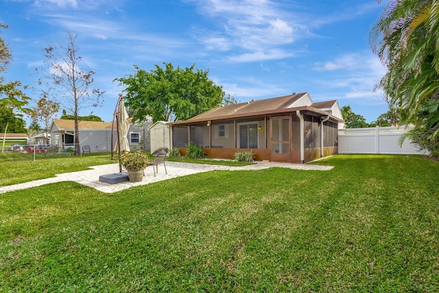 back of house featuring a sunroom, a patio area, and a lawn