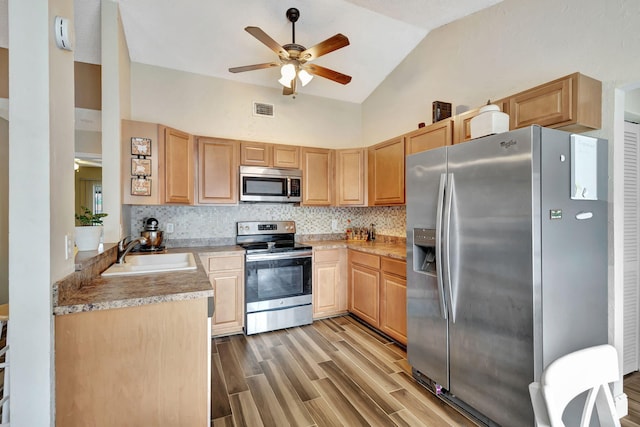 kitchen featuring appliances with stainless steel finishes, tasteful backsplash, light hardwood / wood-style floors, and sink