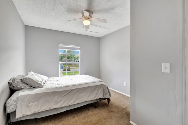 carpeted bedroom featuring ceiling fan and a textured ceiling