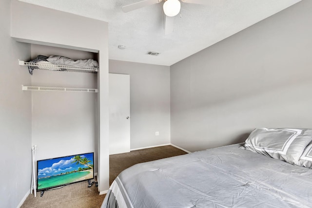 bedroom featuring ceiling fan, a closet, carpet floors, and a textured ceiling