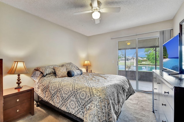 bedroom with ceiling fan, access to exterior, light colored carpet, and a textured ceiling