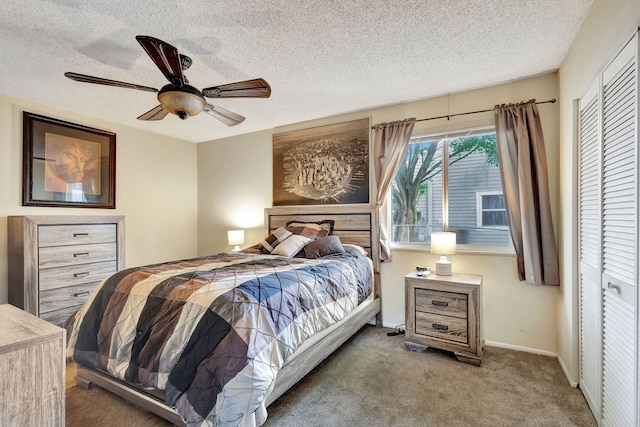 carpeted bedroom featuring ceiling fan, a closet, and a textured ceiling