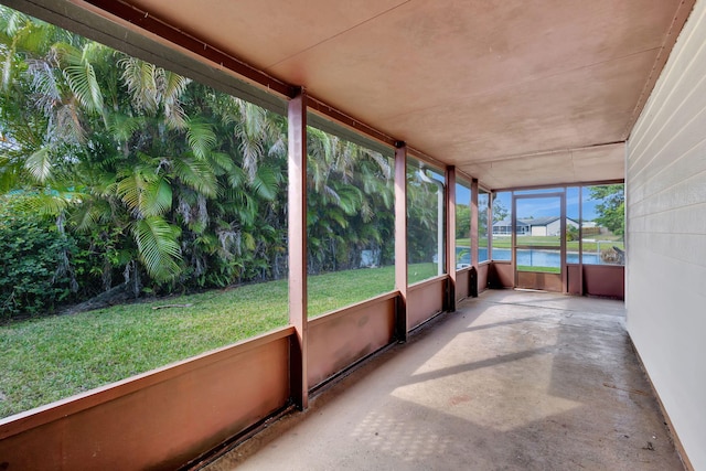 unfurnished sunroom featuring a water view