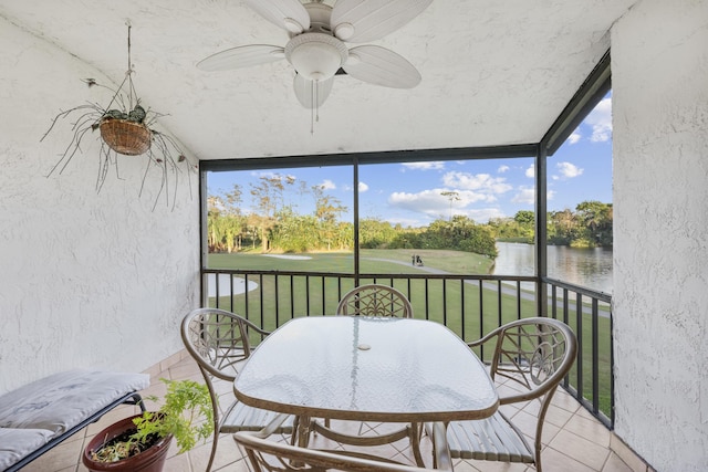 sunroom / solarium featuring a water view and ceiling fan