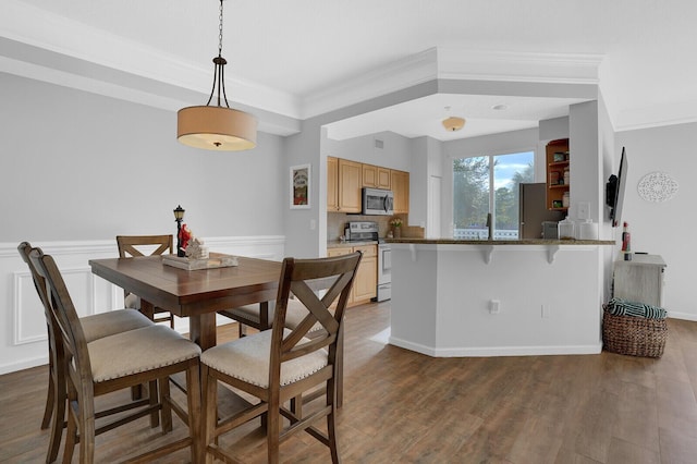 dining space featuring hardwood / wood-style floors, ornamental molding, and sink