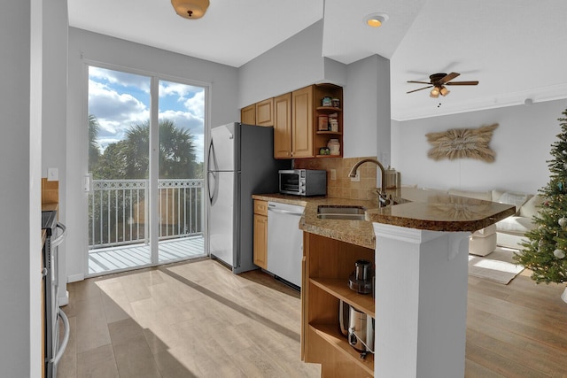 kitchen featuring ceiling fan, sink, tasteful backsplash, kitchen peninsula, and appliances with stainless steel finishes