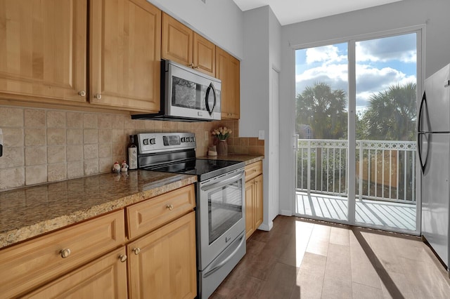 kitchen featuring hardwood / wood-style floors, light brown cabinets, backsplash, light stone countertops, and appliances with stainless steel finishes