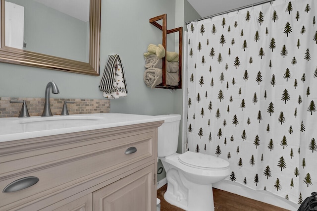 bathroom with hardwood / wood-style floors, vanity, toilet, and curtained shower