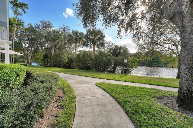 surrounding community featuring a lawn and a water view