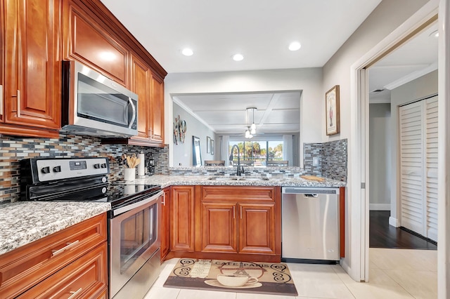 kitchen featuring light tile patterned floors, light stone countertops, sink, and appliances with stainless steel finishes