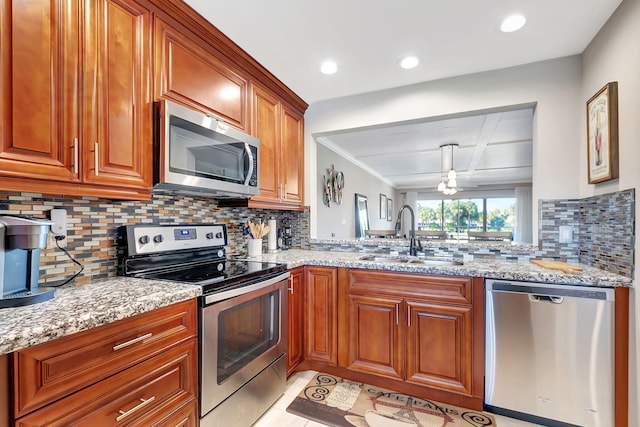 kitchen with light stone counters, sink, and appliances with stainless steel finishes